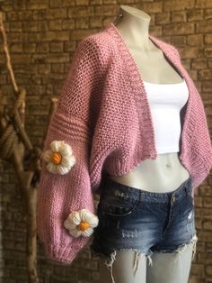 a female mannequin wearing shorts and a pink knitted cardigan with flowers