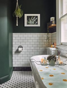 a bathroom with green walls and white tile