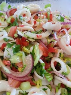 a close up of a salad with onions, tomatoes and lettuce