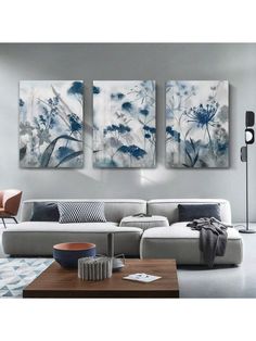 three paintings hanging on the wall in a living room