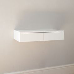 a white shelf sitting on top of a wall