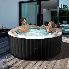 a man and woman sitting in an outdoor hot tub