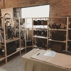 a room filled with lots of boxes and shelves next to a brick wall in front of a window