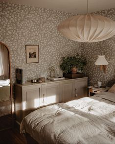 a bedroom with a bed, dresser and lamp in it's centerpieces