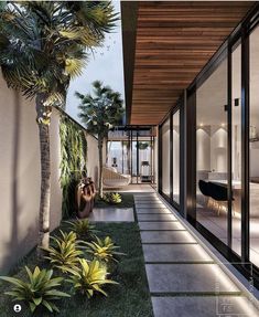 an outdoor area with grass and plants next to a house that has sliding glass doors on both sides