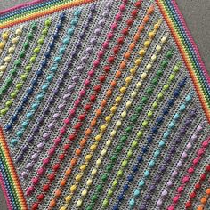 a crocheted blanket with multicolored beads on it