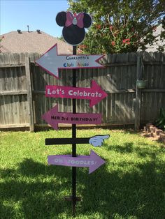 a minnie mouse sign in the yard with lots of signs on it that read, let's celebrate