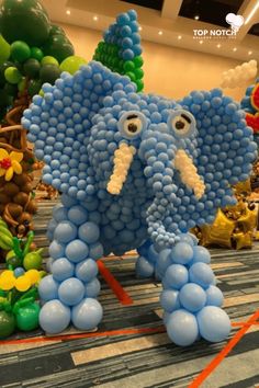 an elephant made out of balloons in the middle of a room with other balloon decorations