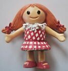 a doll with red hair wearing a pink and white checkered dress holding her hands out