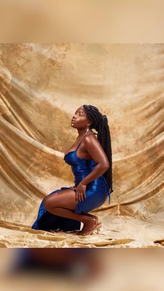 a woman in a blue dress is posing for the camera