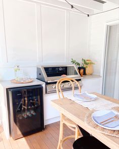 a kitchen with an oven, dishwasher and dining table set for four in it