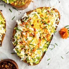 two pieces of bread with different toppings on them next to a small bowl of seasoning