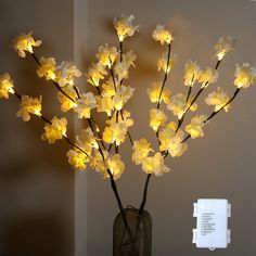 a vase filled with yellow flowers sitting on top of a table next to a wall