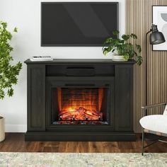 a living room with a fireplace and tv mounted on the wall, next to a chair