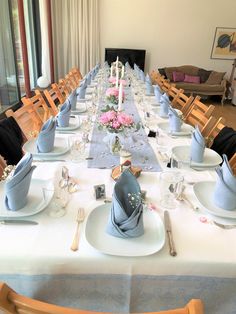 a long table set with place settings and napkins for an elegant dinner or party