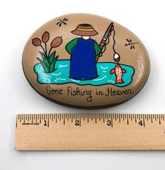 a wooden magnet with a fishing scene on it