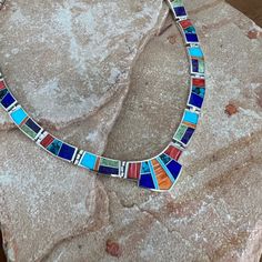 This gorgeous Sterling Silver Necklace is shown in the Indian Summer Collection, features Red & Orange Spiny, Sugilite, Gaspiete, AZ Blue Turquoise, Lapis & Tibetan Turquoise. Dimensions: 19" Total Length; Centerpiece Link: 1 3/8"W x 3/4"H Link Size: 7/8" x 5/16" They are designed by David Rosales, one of the finest contemporary Southwest Artists in the world. He is the founder and co-owner of Supersmiths, Inc. of Gallup, NM. This Handcrafted Necklace is custom made and carries a lifetime guaran Artisan Blue Inlay Necklaces, Unique Blue Necklace With Inlay, Blue Necklace With Round Inlay, Southwestern Blue Necklace With Inlay, Southwestern Blue Inlay Necklace, Traditional Multicolor Necklace With Inlay, Southwestern Style Blue Inlay Necklace, Southwestern Multicolor Gemstone Necklace, Southwestern Style Multicolor Gemstone Necklace