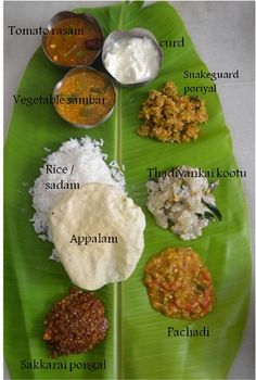 a banana leaf with different types of food on it, including rice and sauces