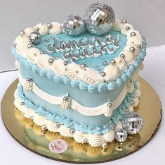 a blue and white birthday cake with disco balls on top