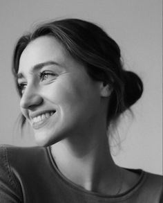 a black and white photo of a woman smiling