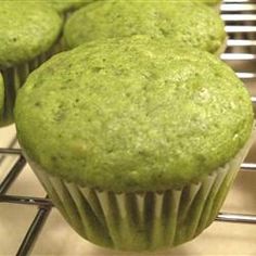 some green muffins are cooling on a rack