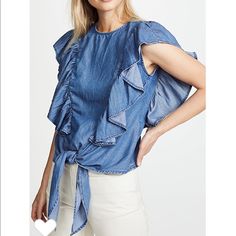 This Chambray Blouse Imparts A Sweet And Feminine Feel With A Flouncy Ruffle Flutter Falling From Shoulder To Waist, Finished With A Tie Front Hem. Snaps Down The Back Add A Nod To A More Classic Denim Look, Balancing The Ornate Front. - Color: Springfield - 62% Tencel 23% Cotton 15% Linen - Made In Usa Measurements: Bust:32” Length:21” High Neck Sleeveless Top, Ruffle Trim Top, Mock Neck Blouse, Tie Neck Tops, Linen Blouse, Collar Blouse, Red Blouses, Frame Denim, Striped Blouse