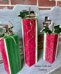 three watermelon painted wooden boxes sitting on a shelf next to a brick wall