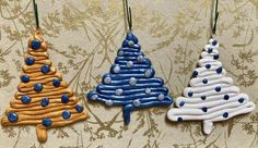 three decorated christmas trees hanging from hooks