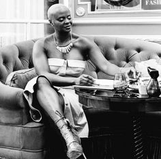 a black and white photo of a man sitting on a couch in front of a table