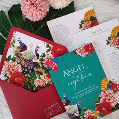 an envelope and some cards with flowers on them next to each other in front of a bouquet of pink carnations