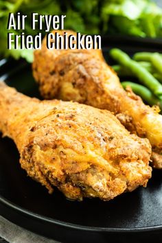 air fryer fried chicken on a black plate with green beans and broccoli