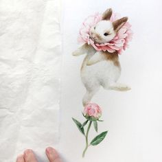 a person holding up a piece of paper with an image of a rabbit on it