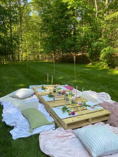 a picnic table with flowers and candles on it in the middle of a grassy area