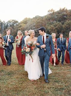 the bride and groom are walking with their bridal party