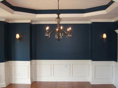 an empty room with blue walls and chandelier