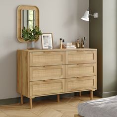 a wooden dresser sitting next to a window in a room with hardwood floors and walls