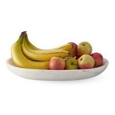 a white bowl filled with bananas and apples