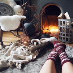 a person with their feet up in front of a fireplace