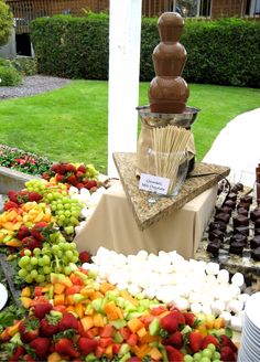 an assortment of fruits and chocolates on display in front of a building with grass