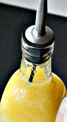 a yellow liquid in a glass bottle with a metal cap