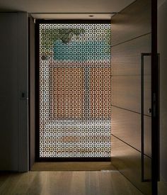 an open door in a room with wood flooring and glass doors on both sides