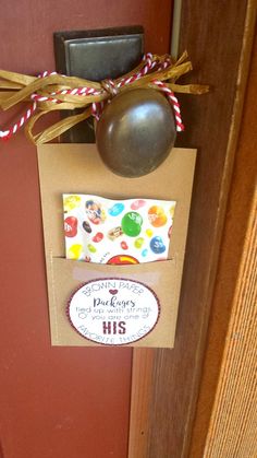 a door hanger with a ball and some candy on it's side, attached to the front door