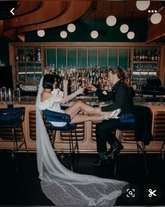 a man and woman sitting at a bar with their feet on each other's legs