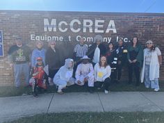 a group of people standing in front of a sign