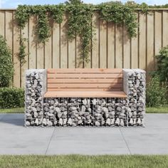 a wooden bench sitting next to a stone wall