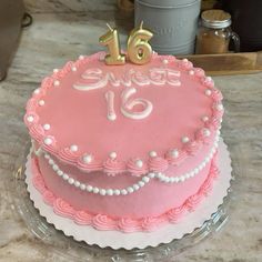 a pink birthday cake with the number sixteen on it