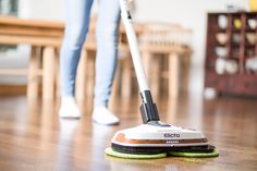 a woman is cleaning the floor with a mop