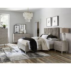 a bedroom with a bed, dressers, and mirror in it's center