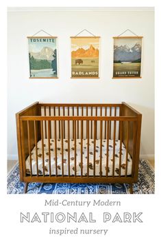 a baby crib in the middle of a room with two pictures on the wall