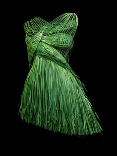 a dress made out of grass on a black background